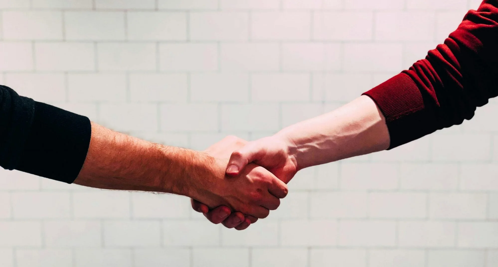 2 Menschen geben sich die Hand.
